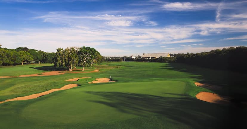 Aerial view of a golf course fairway with sand bunkers and dramatic sky