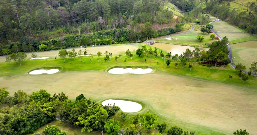 Aerial view of a golf course with tropical trees and sand bunkers