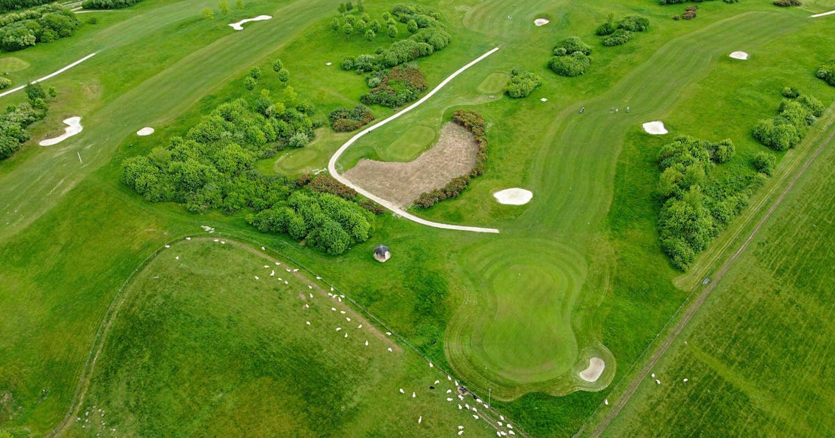 Aerial drone view of a golf course fairway and sand bunkers